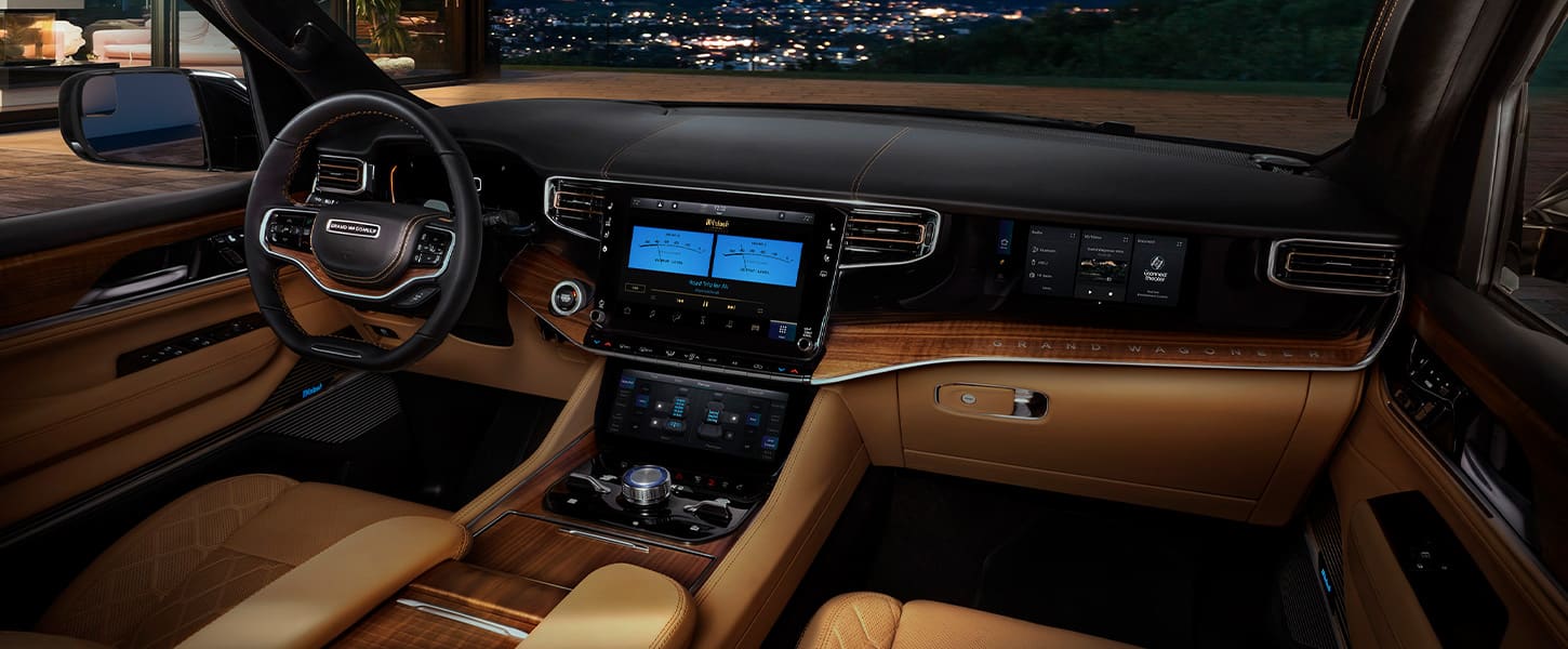 A sweeping view of the instrument panel, dash, steering wheel and touchscreen in the 2022 Wagoneer.